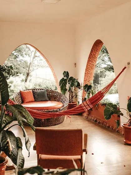 An earthy, rustic texture applied to arched walls in a sunroom. This finish complements the natural light and greenery, creating a seamless connection between the indoor and outdoor environment.