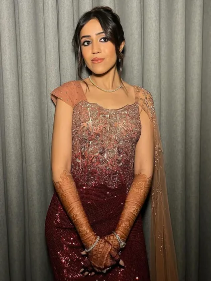 The full sangeet look. The messy French twist adds a touch of sophistication to her stunning embellished gown, creating a look that is both glamorous and effortlessly chic.