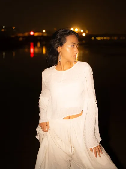 A profile shot with the city lights reflecting on the water. This adds another layer of light and interest to the night portrait.