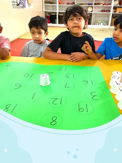 A group of four boys works together on a number game, showing intense focus and collaboration. We encourage peer learning to make educational activities more dynamic and enjoyable.