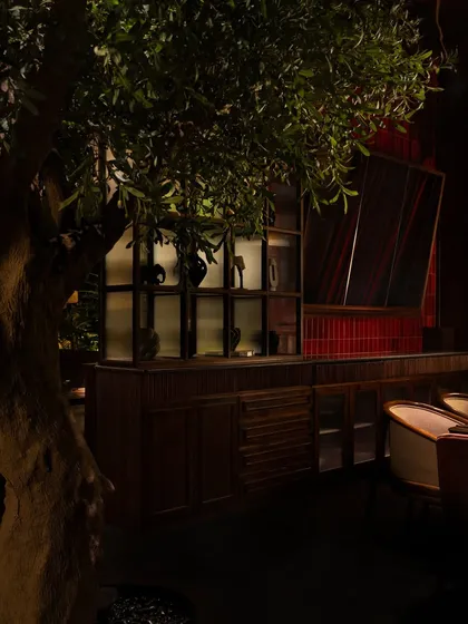 A quiet corner where a wooden credenza and curated objects create a residential, almost personal, feel.