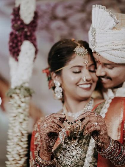 A sweet moment where the groom helps the bride with her jewelry during the ceremony.