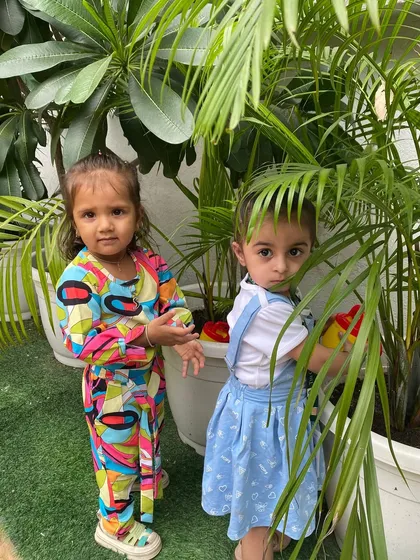 Exploring the textures and shapes of leaves while watering the plants. Outdoor time is a multi-sensory experience that we integrate into our daily routine.