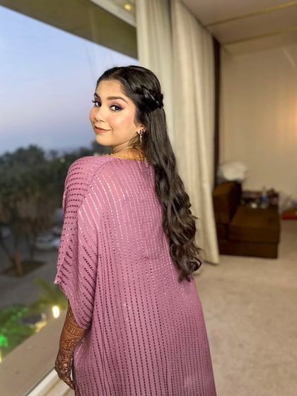 A side profile showing the half-up braided hairstyle, perfect for keeping hair off the face during pre-wedding festivities.
