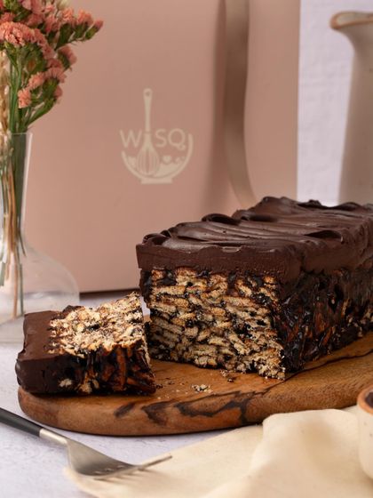 My chocolate biscuit cake, also known as lazy cake, is perfect for satisfying sweet cravings. It's presented here on a wooden board, ready to be sliced and shared.