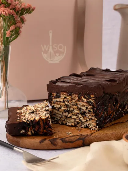 My chocolate biscuit cake, also known as lazy cake, is perfect for satisfying sweet cravings. It's presented here on a wooden board, ready to be sliced and shared.