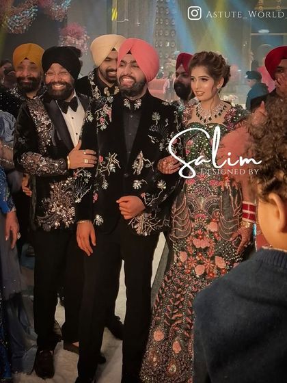 A groom at his wedding, surrounded by family, wearing a custom black tuxedo with intricate floral embroidery. My goal is to make the groom feel his absolute best on his big day.