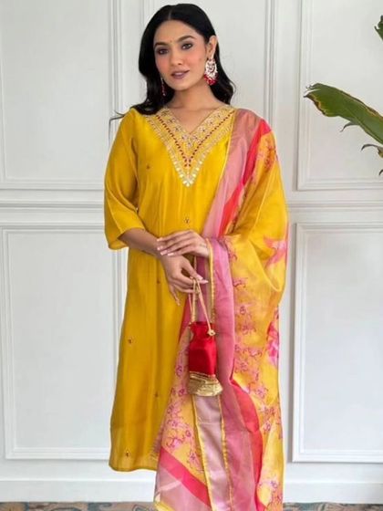A vibrant mustard kurta set with a contrasting pink and yellow printed dupatta. It's a cheerful and stylish outfit that's perfect for a sunny day.