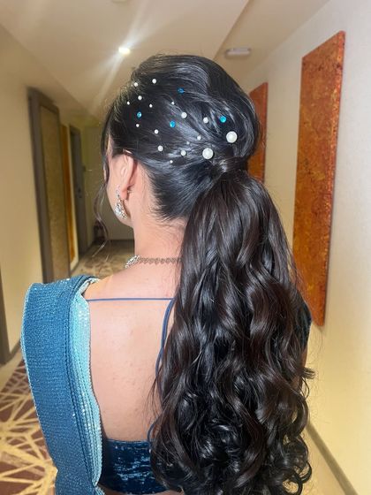 A close-up of the pearl and gem ponytail, showing the beautiful details and the voluminous curls.