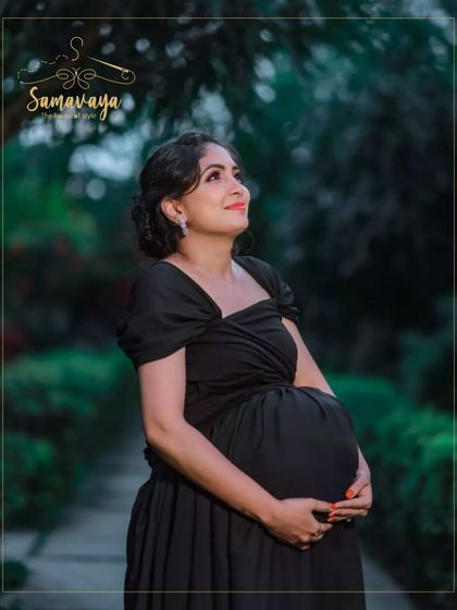Looking up towards the light, this is a hopeful and dreamy portrait of an expecting mother in a timeless black gown.
