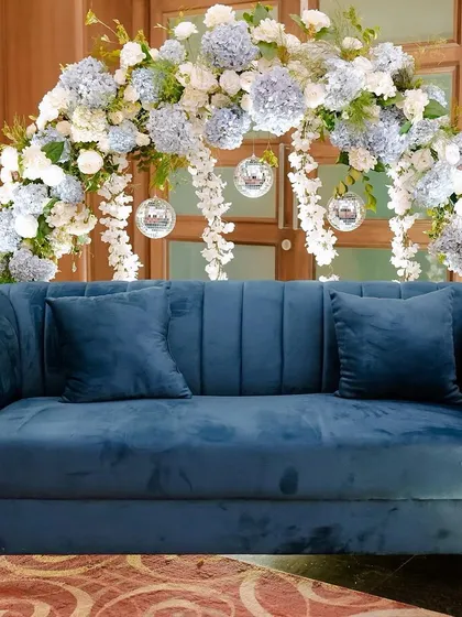 A clean shot of the Sangeet photo booth decor. The combination of the rich blue velvet, the cool-toned flowers, and the sparkling disco balls created a look that was both sophisticated and fun.
