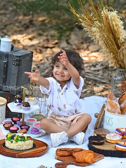 An expressive, happy moment as the child reaches out during his picnic photoshoot.