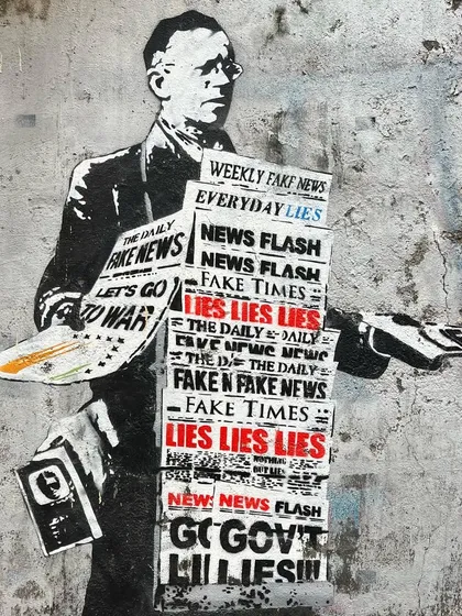 A thought-provoking piece of stencil art commenting on "fake news," showcasing the political and social commentary present in Mumbai's street art scene.