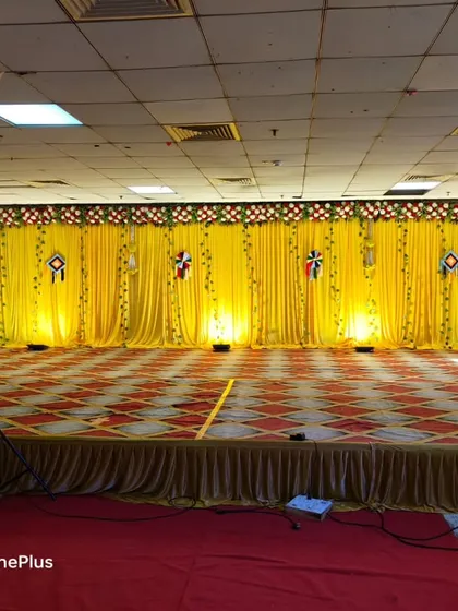 A classic Haldi ceremony stage with a bright yellow curtain backdrop. I use simple uplighting to enhance the color and create a focal point for the rituals, with speakers placed on the sides for music.