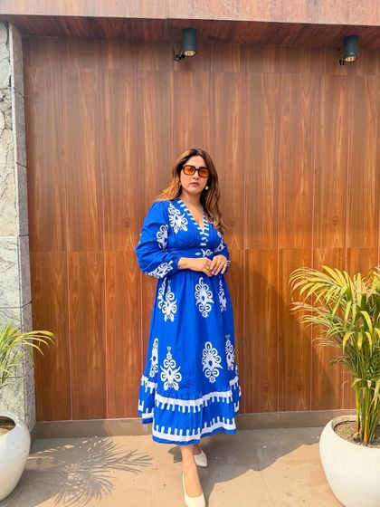 This vibrant blue and white embroidered dress is a perfect example of a dressy piece for your wardrobe. It's eye-catching, comfortable, and perfect for a summer event.