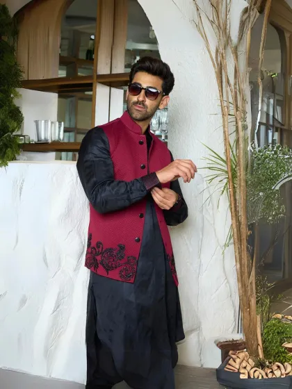 This black silk kurta and maroon waistcoat set is a perfect blend of structure and luxury. The rich textures come together for a look that is effortlessly stylish and timeless.