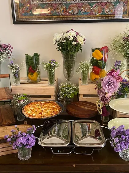 A clean and fresh grazing table setup perfect for a daytime event. We used plenty of baby's breath and purple flowers to complement the food display, which includes pizzas and appetizers.