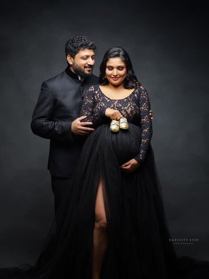 A sweet couple's portrait using tiny baby shoes as a prop. This shot is a classic way to signify the little one on the way.