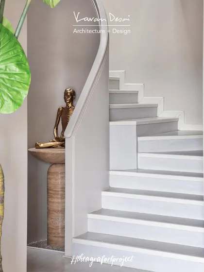 At the base of the staircase in the Agra Fort Project, a custom travertine console holds a bronze statue, creating a moment of peace and reflection. This is how I integrate spiritual elements into a modern home.
