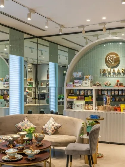 Eclectic and jolly interiors can lift the spirits. This space, designed for Izzhaar, bursts with vibrant colors and an exciting mix of prints and materials. The mint green tiled arch and curved sofa create a playful yet sophisticated retail environment.