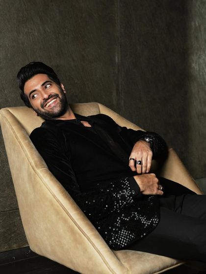 A relaxed, candid-style portrait of actor Akshay Oberoi. The warm, soft lighting creates an inviting and approachable mood.