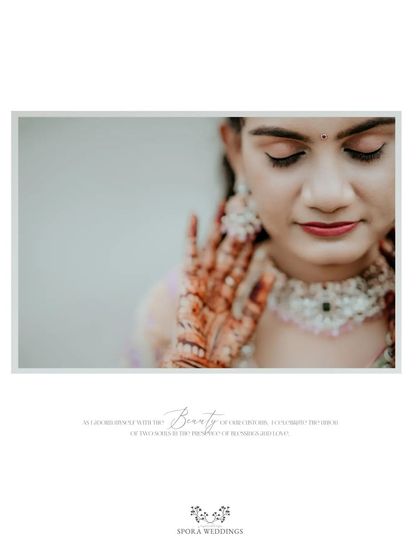 A close-up portrait of a bride, her eyes closed, showcasing her intricate henna and the beauty of her customs.