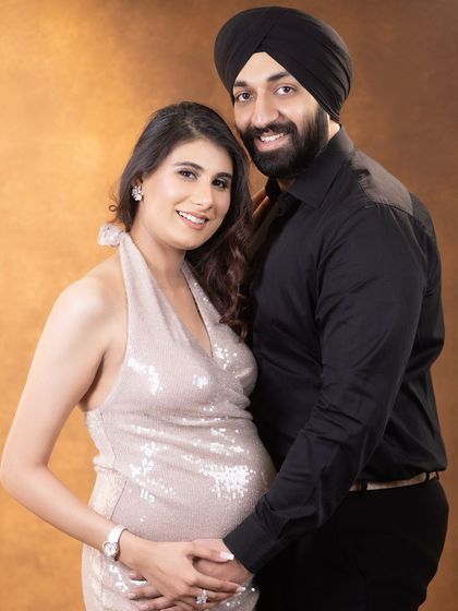 A classic and elegant couple's portrait. This pose showcases the baby bump beautifully while highlighting the strong and supportive bond between the partners.