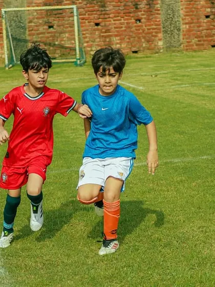 Two young players battling for the ball during a U8 Pride Cup match. We encourage healthy competition and determination.