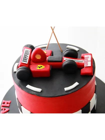 Another take on the Ferrari F1 theme, this time with the car on a fondant racetrack. The checkered flag pattern on the side adds to the racing excitement.