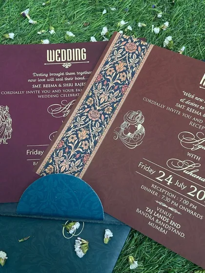 A beautiful flatlay of wedding and reception inserts in maroon and brown, featuring an ornate floral border that adds a touch of vintage charm.