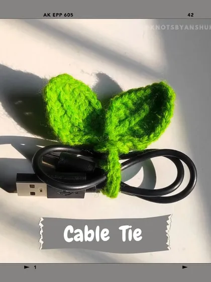 Tired of tangled cables? This crochet cable tie, shaped like a little green sprout, is a cute and simple solution to keep your chargers organized.