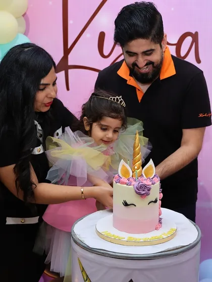 A sweet family moment as Kyra cuts her unicorn-themed 3rd birthday cake.