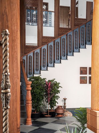 The grand staircase, with its contrasting teak and steel blue, is a testament to our belief in making every part of the home, even transitional spaces, a work of art.