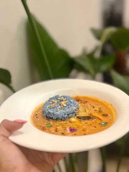 A comforting bowl of Thai Penang Coconut Lime Curry, served with a mound of our signature blue pea flower rice.