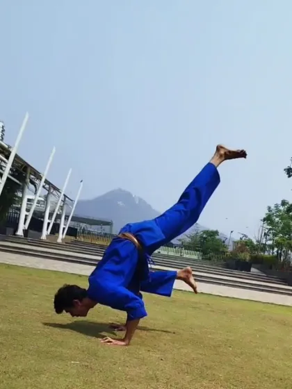 Our training philosophy blends the power of karate with the control of yoga. Here, an instructor executes a variation of the Mayurasana arm balance, showcasing incredible strength and stability.