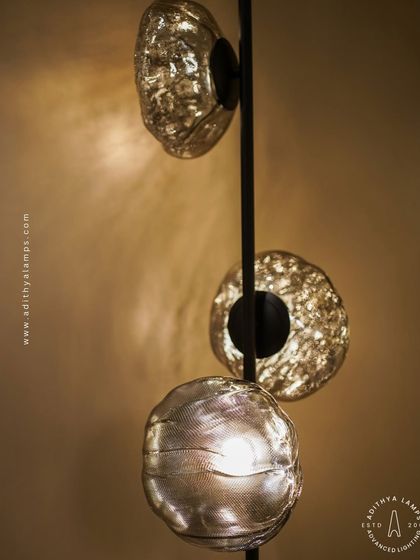 This vertical fixture features textured, moon-like chrome orbs attached to a central black rod. It's a striking, artistic piece that works well in corners or narrow spaces, adding a touch of celestial-inspired modernism.