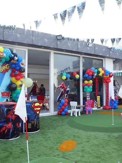 A full view of a superhero party setup in our outdoor area, combining themed decorations with play space.