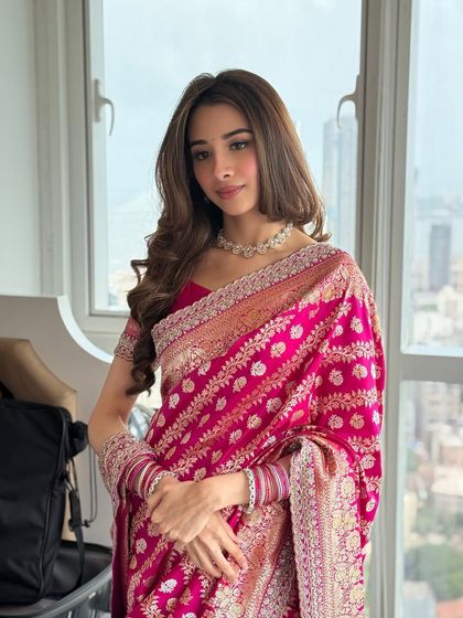 A classic engagement look featuring a beautiful pink Banarasi saree. The makeup is soft and timeless, with defined eyes and a matte pink lip.