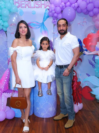 A stylish family portrait at our mermaid-themed party. The "under the sea" backdrop with its shades of purple and teal creates a beautiful setting for photos.