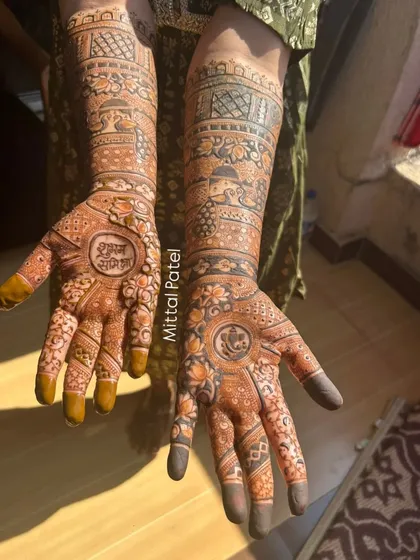 A sun-kissed photo of a bridal mehndi, featuring "Shubh Labh" (auspicious gains) and a Ganesha motif for good luck.