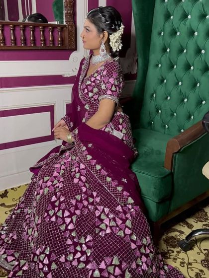 Seated gracefully, this client shows off the rich colour and intricate details of her wine-coloured rental lehenga. It’s a perfect look for a formal evening event.