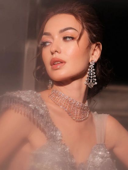 A dreamy, soft-focus portrait of a model in a silver-grey gown.