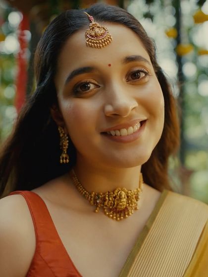 A close-up of a radiant bride from the Kushal's Jewellery campaign. This traditional South Indian bridal look features a classic temple jewellery choker and maang tikka, paired with warm, glowing makeup and a simple bindi.
