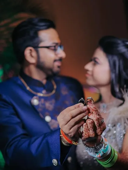 A creative shot focusing on the couple holding their engagement rings. This highlights the central theme of the ceremony in a unique way.