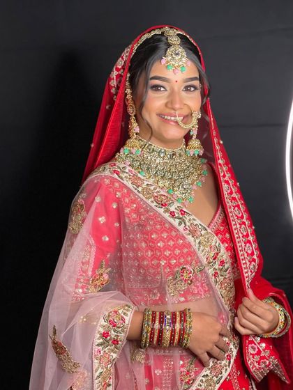 The perfect smiling bride in a classic red lehenga with a sheer dupatta. This look is both traditional and elegant, perfect for your pheras.