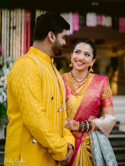 A sweet moment between the bride and groom. Her traditional Maharashtrian look, with the simple hairstyle and gold jewelry, is just perfect.