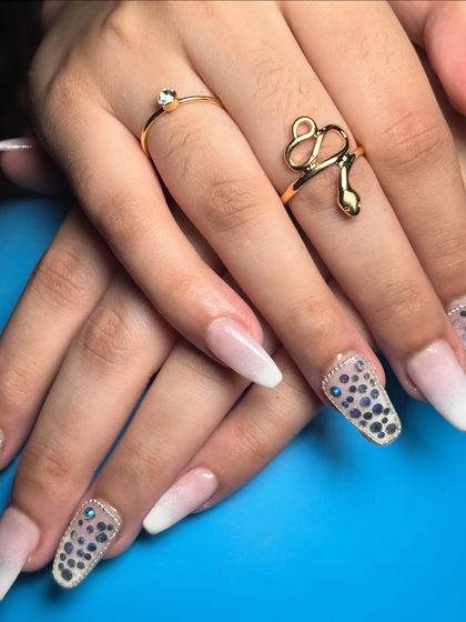 The complete look, showing the balance between the simple white ombré and the dazzling stone accent nails.