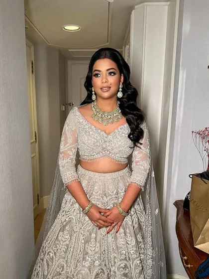 The full look for Shreya's reception. Her makeup perfectly complements her stunning ivory lehenga and diamond jewelry.