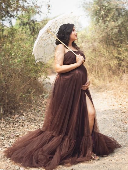 Using a vintage lace parasol as a prop adds a touch of timeless romance to this outdoor portrait. It creates a soft, dreamy look that is perfect for a nature-filled maternity session.