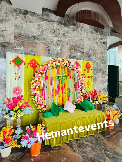 A bright and cheerful Mehendi corner, perfect for taking photos. The combination of a floral arch, colorful hangings, and a comfortable diwan makes it a focal point of the event.
